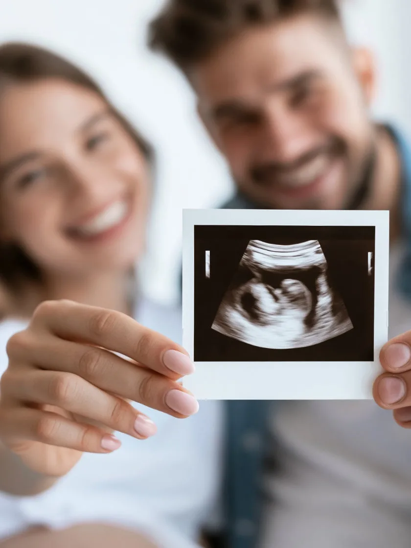 young couple holding ultrasound photo toward camera, happy pregnancy announcement atmosphere with soft indoor lighting and blurred background, airy atmosphere, wide negative space --ar 16:9 --seed 2801848490 --raw --profile 286piie --stylize 50 --hd --v 8.1 Job ID: 566ddda9-2a71-475c-b267-73b2f03a9255